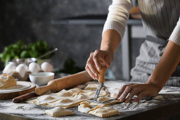 Mulher fazendo ravioli saboroso na mesa
 - Foto, Imagem