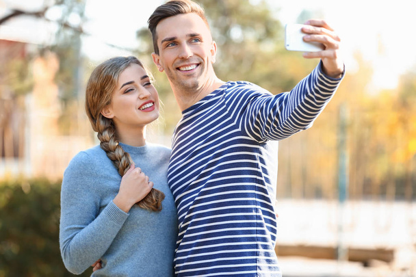 Happy loving couple taking selfie outdoors - Photo, Image