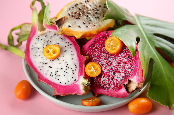 Тарелка с вкусными фруктами дракона на цветном фоне
 - Фото, изображение