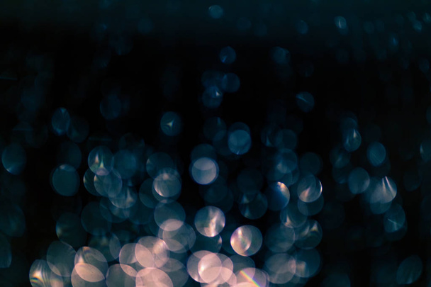 bokeh of lights made by raindrops on a windows illuminated by a torch, abstract background or texture shot - Fotó, kép