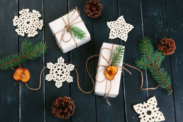 Christmas composition of Christmas gifts with pine cones and fir branches on wooden background - Fotó, kép