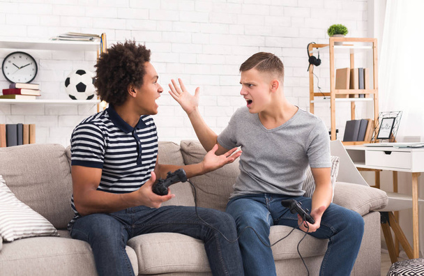 Підліткові геймери сперечаються під час гри на консолі
 - Фото, зображення
