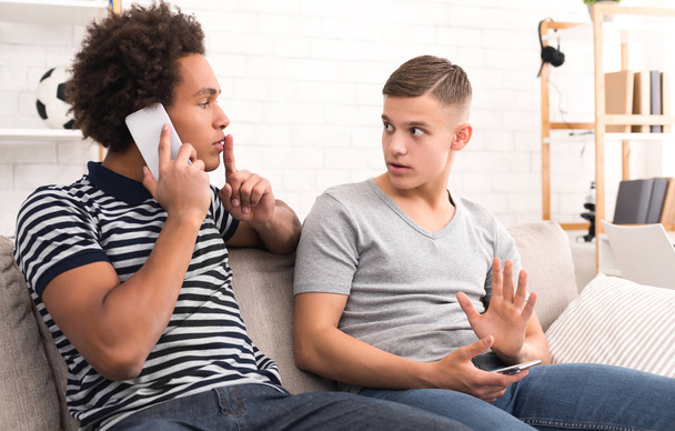 Хлопець просять мовчання під час розмови по телефону - Фото, зображення
