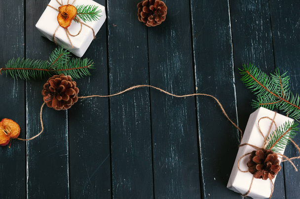 Christmas composition of Christmas gifts with pine cones and fir branches on wooden background - Φωτογραφία, εικόνα