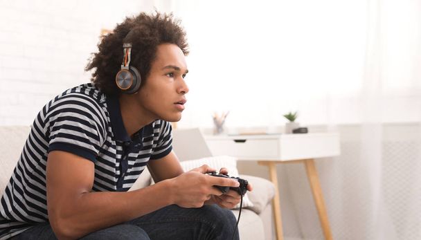 Concentrated teenager playing video games with joystick - Photo, image