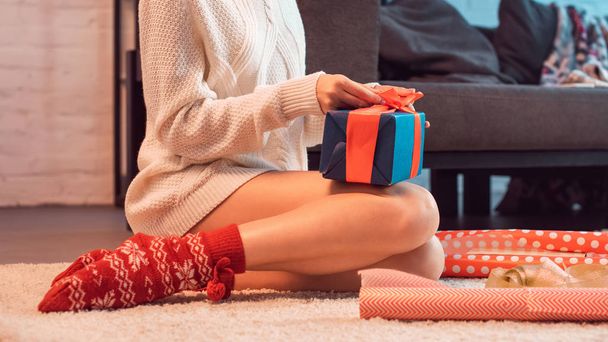 Ausgeschnittene Ansicht einer Frau, die zu Weihnachten sitzt und Geschenke einwickelt  - Foto, Bild