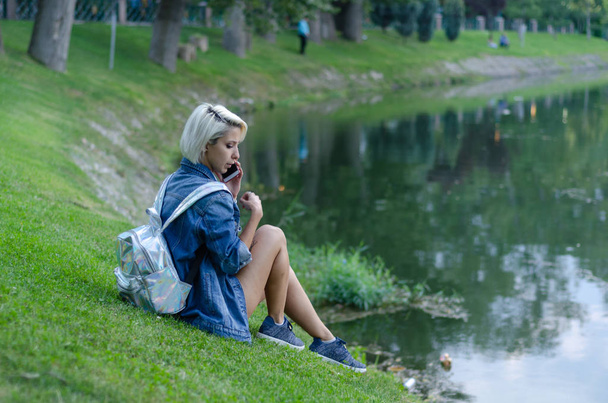 Pretty woman talking on phone at the park. - 写真・画像