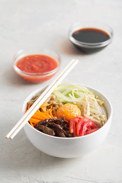 Traditional Asian Bibimbap dish with rice and vegetables - 写真・画像