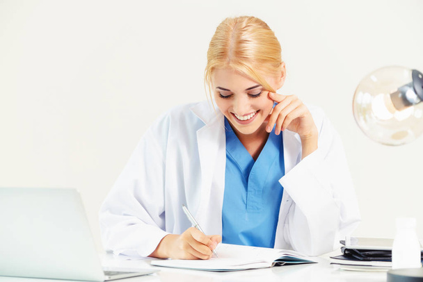 Nő orvos a kórházi vagy az egészségügyi Intézet orvosi jelentés irodai asztal dolgozik. - Fotó, kép