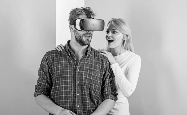 Man VR glasses involved video game while girl try to wake him up. Video game addiction symptoms and treatment. Video game captured imagination of guy. Wife tries to help him back into real life - Foto, Imagen