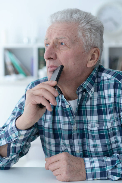 senior man with phone at home  - Foto, Bild
