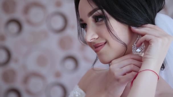 Very beautiful girl gently puts on earrings.. - Footage, Video