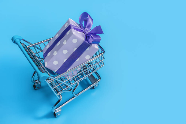 Gifts for Christmas, packed in box, wrapped in purple paper polka dot. Shopping cart, holiday shopping. - Foto, Imagem