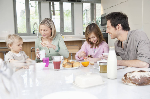 Szczęśliwa rodzina bawiąc się na stole śniadaniowym - Zdjęcie, obraz