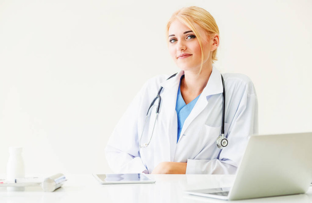 Женщина-врач в больнице или институте здравоохранения работает над медицинским отчетом за рабочим столом
. - Фото, изображение