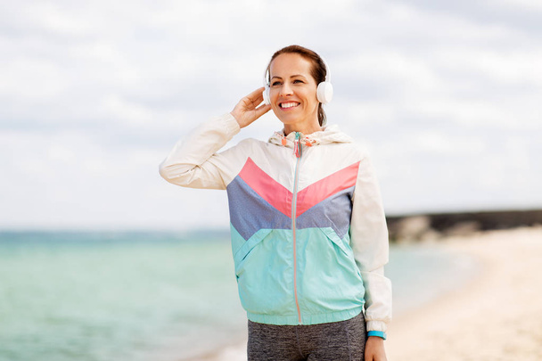 sporty woman with headphones on beach - Foto, imagen