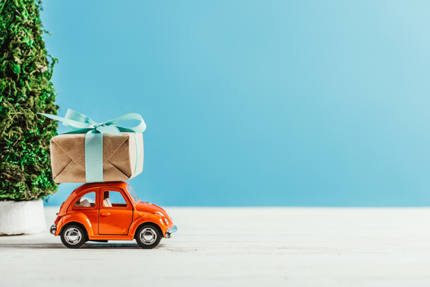 Close-up shot van speelgoed voertuig met de doos van de gift op blauwe achtergrond - Foto, afbeelding