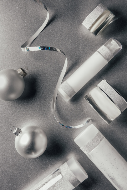 top view of christmas balls, ribbon and beauty treatment equipment on silver  - Photo, Image