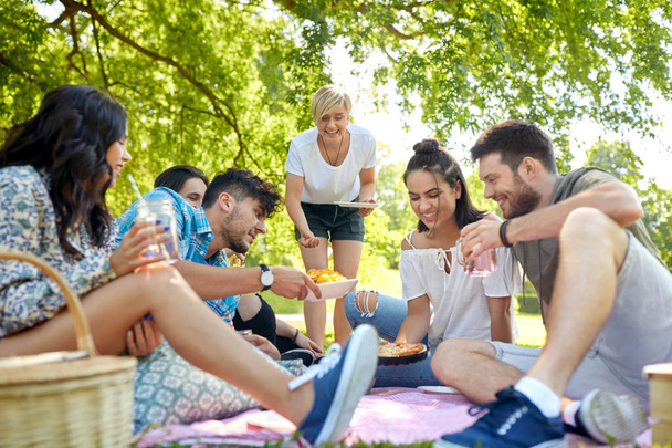 friends with drinks and food at picnic in park - Fotoğraf, Görsel