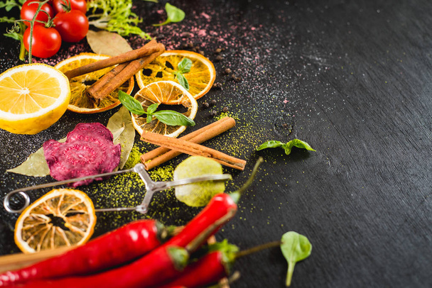 Differen vegetables food ingredients and spices on black background - Photo, image