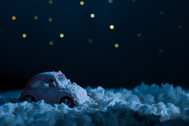 zbliżenie zabawki samochód stojący w śniegu w noc pod gwiaździste niebo, koncepcja Boże Narodzenie - Zdjęcie, obraz