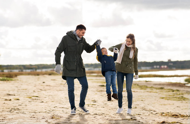happy family walking along autumn beach - Fotó, kép