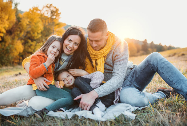 A portrait of young family with two small children in autumn nature at sunset. - Foto, imagen