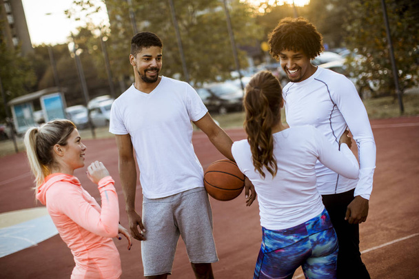 Gruppo di giovani multietnici che giocano a basket in campo
 - Foto, immagini