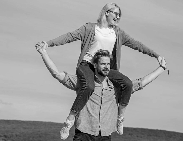 Soulmates enjoy freedom together. Couple happy date having fun together. Freedom concept. Man carries girlfriend on shoulders, sky background. Couple in love enjoy freedom outdoor sunny day - Fotó, kép