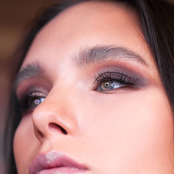 Close up view of blue woman eye with beautiful shades and black eyeliner makeup. Classic make up. Perfect brows. Studio shot - Zdjęcie, obraz