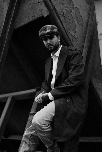 fashionable young bearded man in stylish cap posing    - Фото, изображение