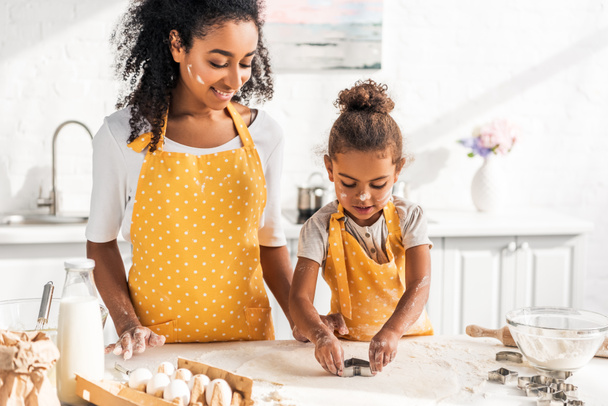 african american mother and daughter preparing cookies with molds in kitchen - Foto, Imagem