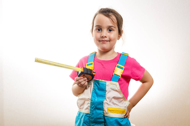 Portrait of girl builder with tape-measure isolated on white backgroundac - Фото, зображення