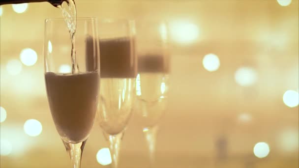 Champagner aus Flasche in eine Flöte über blinkendem Lichterhintergrund gießen - Filmmaterial, Video