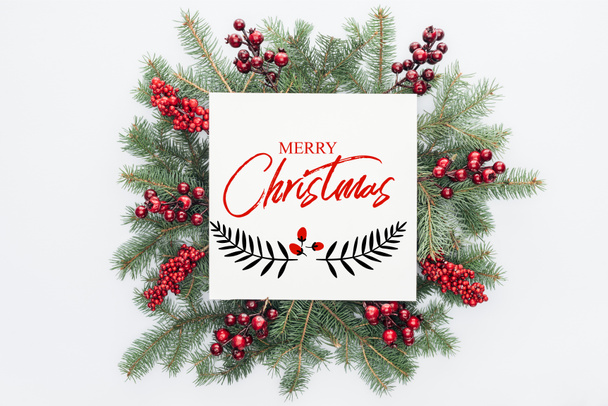 メリー クリスマス の文字白で隔離中のクリスマスの装飾とパイン ツリー花輪の平面図 ロイヤリティフリー写真 画像素材