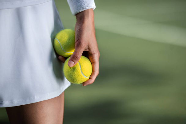 Jugador de tenis en ropa deportiva con un primer plano de pelota
 - Foto, imagen