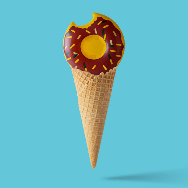 Inflatable donut pool toy with ice cream cone on pastel blue background. Minimal summer concept. - Foto, afbeelding