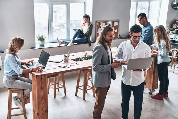 men using laptop, brainstorming business people in creative modern office studio  - Photo, Image