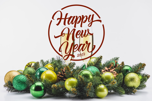 glass of champagne and festive christmas wreath on white backdrop with "happy new year 2019" lettering - Fotoğraf, Görsel
