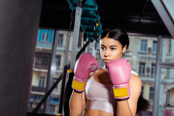 Menina forte atraente em luvas de proteção praticando boxe no ginásio
  - Foto, Imagem