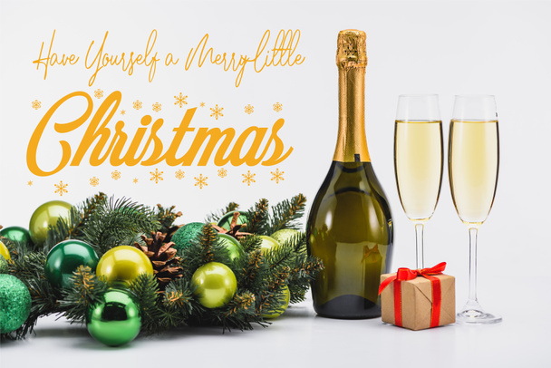 bottle and glasses of champagne, christmas wreath and gift on white background with "have yourself a merry little christmas" inspiration  - Photo, Image
