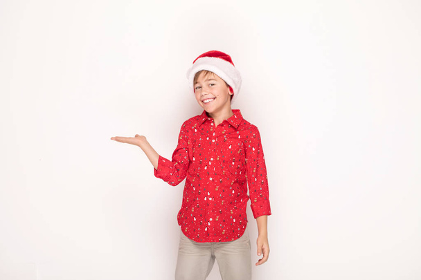Funny smiling child boy in Santa red hat posing on white background. - Фото, зображення