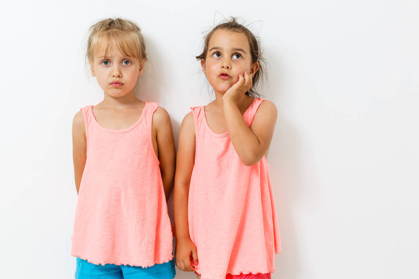 Két kis lány pózol a fehér háttér  - Fotó, kép