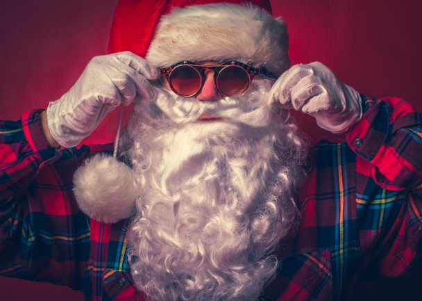 Graves Santa Claus fresco con gafas de sol en el fondo rojo
. - Foto, imagen