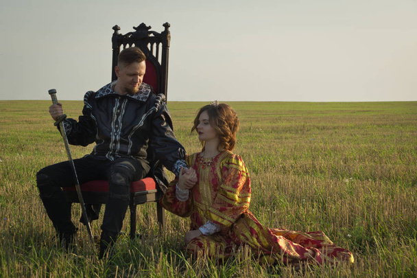 Knight with sword and girl in vintage dress in summer fiel - Foto, Imagem