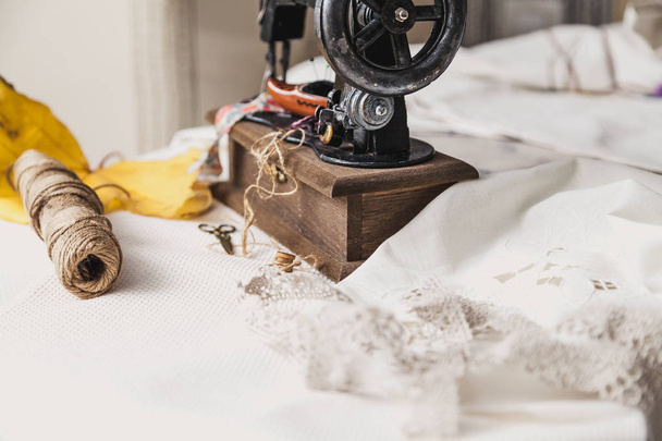 Autumn still life with a sewing machine. Vintage sewing machine and a skein of threads. A yellow maple leaf lies nearb - Φωτογραφία, εικόνα