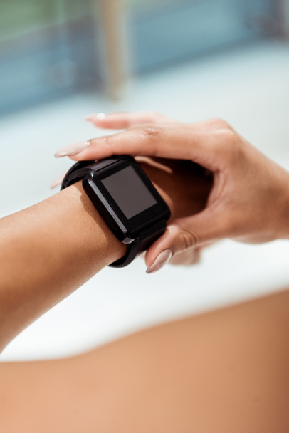 Partial view of girl using fitness tracker - Foto, imagen