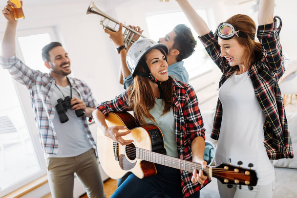 Cheerful young friends having party together and playing instruments - Photo, Image