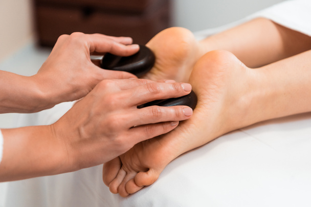 Nahaufnahme Teilansicht einer Frau mit Hot-Stone-Massage im Wellness-Salon - Foto, Bild