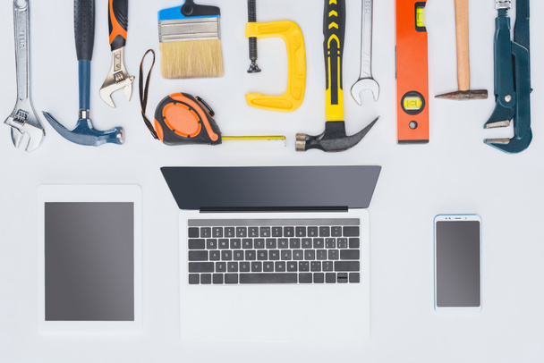 top view of laptop with various tools lying on white - Photo, Image